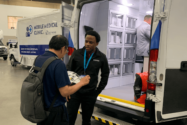 Discussing a vehicle at the Mobile Healthcare Association conference.